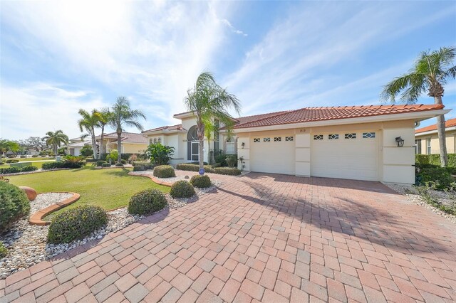 mediterranean / spanish house with a garage and a front lawn