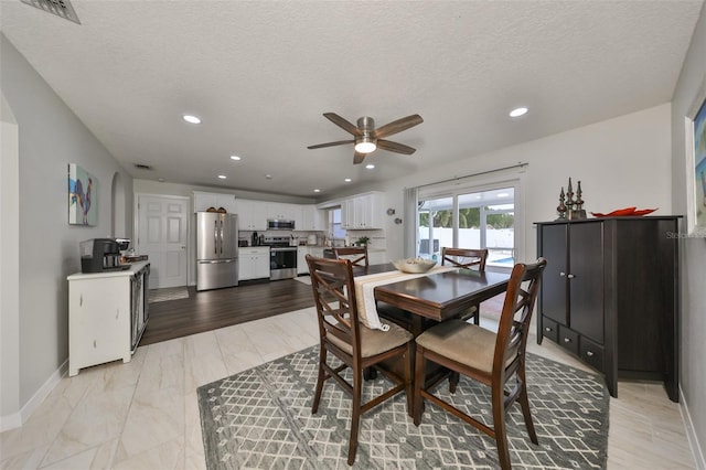 dining area with a textured ceiling and ceiling fan