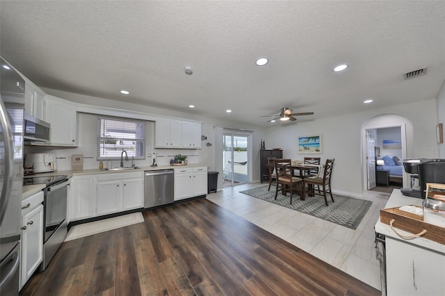 kitchen with sink, white cabinets, a textured ceiling, and appliances with stainless steel finishes