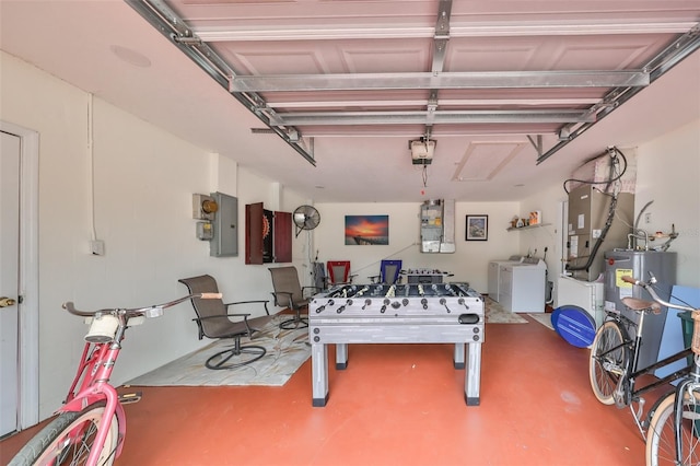 garage featuring heating unit, water heater, washer and dryer, electric panel, and a garage door opener