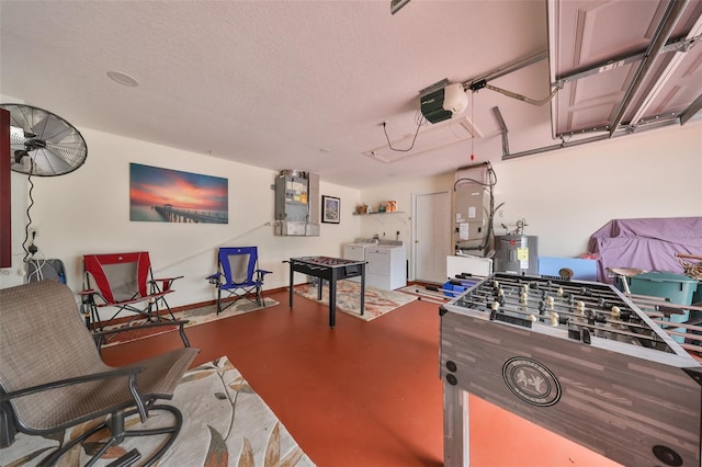 rec room with concrete flooring, electric water heater, washer and dryer, and a textured ceiling