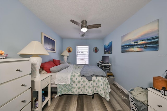 bedroom with hardwood / wood-style floors, ceiling fan, and a textured ceiling