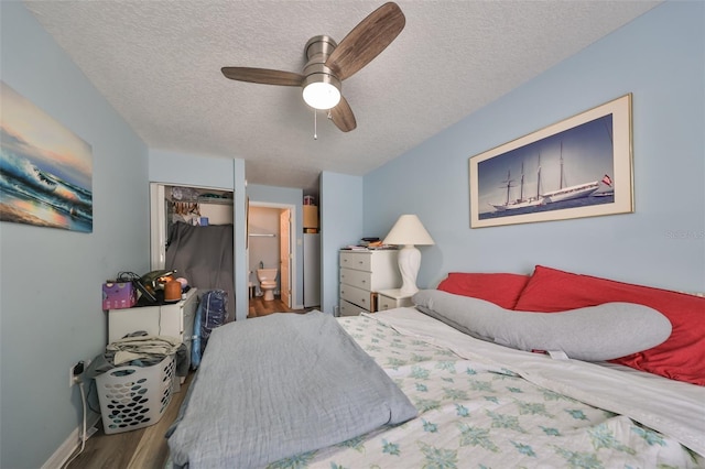 bedroom with ensuite bath, a textured ceiling, ceiling fan, wood-type flooring, and a closet