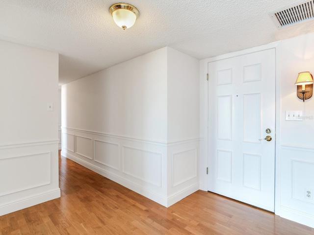 entrance foyer with hardwood / wood-style floors and a textured ceiling