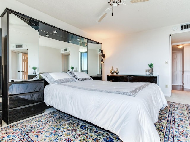 bedroom with ceiling fan and a textured ceiling