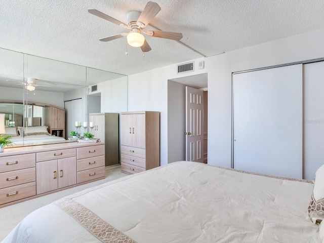 bedroom with light carpet, a textured ceiling, and ceiling fan