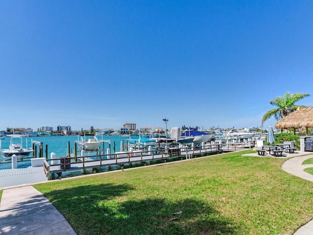 view of dock with a yard and a water view