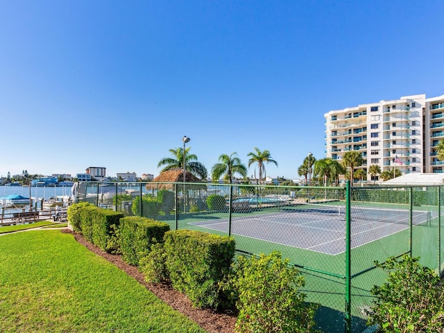 view of tennis court featuring a water view