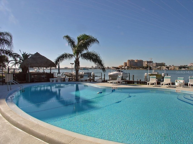 view of pool with a water view and a patio