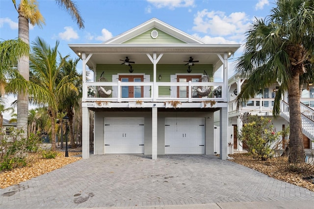 raised beach house with a garage and ceiling fan