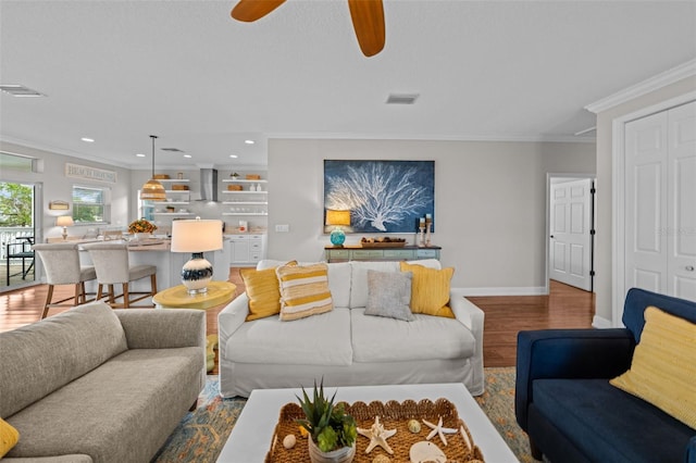 living room with ceiling fan, wood-type flooring, and crown molding