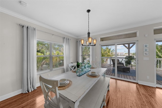 dining room featuring crown molding, light hardwood / wood-style flooring, and an inviting chandelier