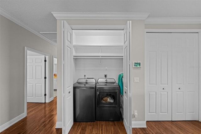 washroom with dark wood-type flooring, washer and dryer, a textured ceiling, and ornamental molding