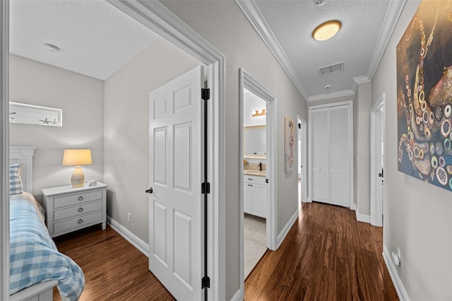 hall featuring a textured ceiling, dark wood-type flooring, ornamental molding, and sink