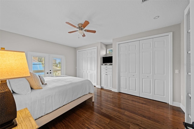 bedroom featuring multiple closets, ceiling fan, and dark hardwood / wood-style flooring