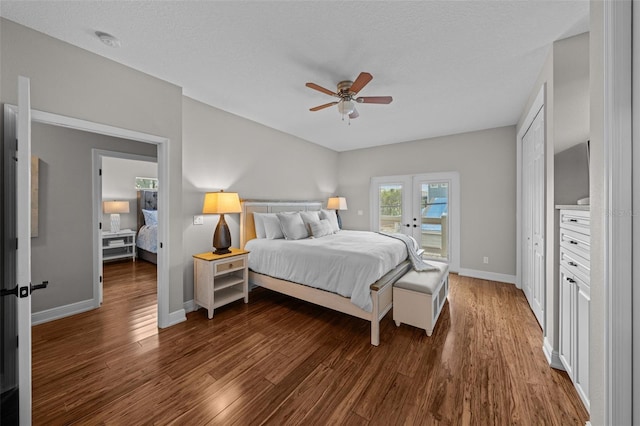 bedroom featuring a textured ceiling, ceiling fan, dark wood-type flooring, and french doors