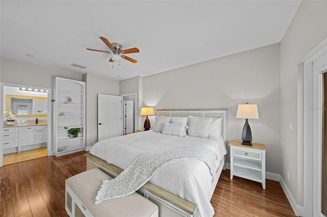 bedroom featuring ensuite bath, ceiling fan, hardwood / wood-style floors, and sink