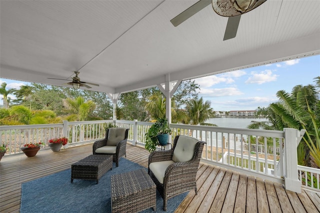 wooden deck with ceiling fan and a water view