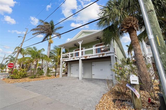 view of front of house with a balcony, a garage, and ceiling fan