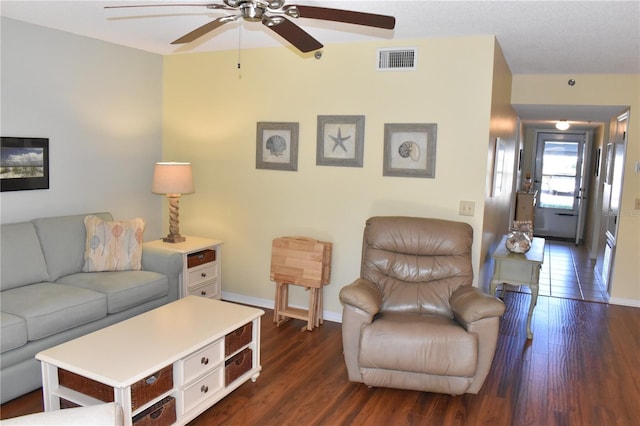 living room featuring ceiling fan and dark hardwood / wood-style flooring