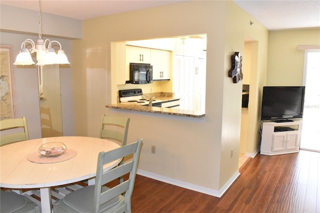 dining room featuring an inviting chandelier and dark hardwood / wood-style flooring