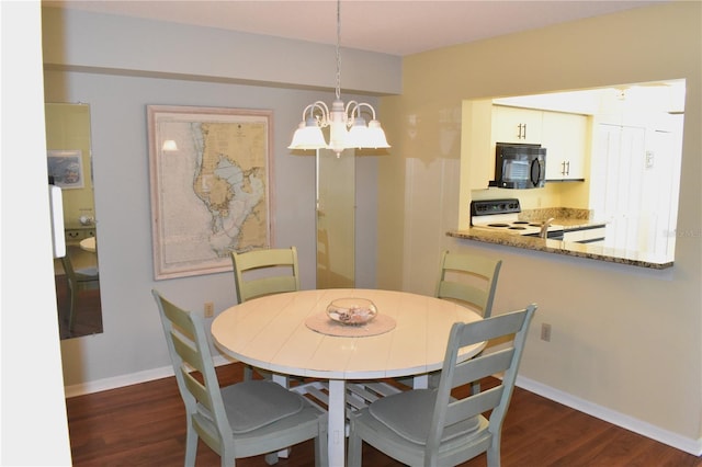 dining space featuring dark hardwood / wood-style flooring and an inviting chandelier