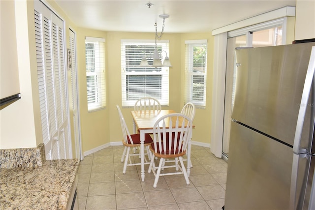 tiled dining area with plenty of natural light and an inviting chandelier