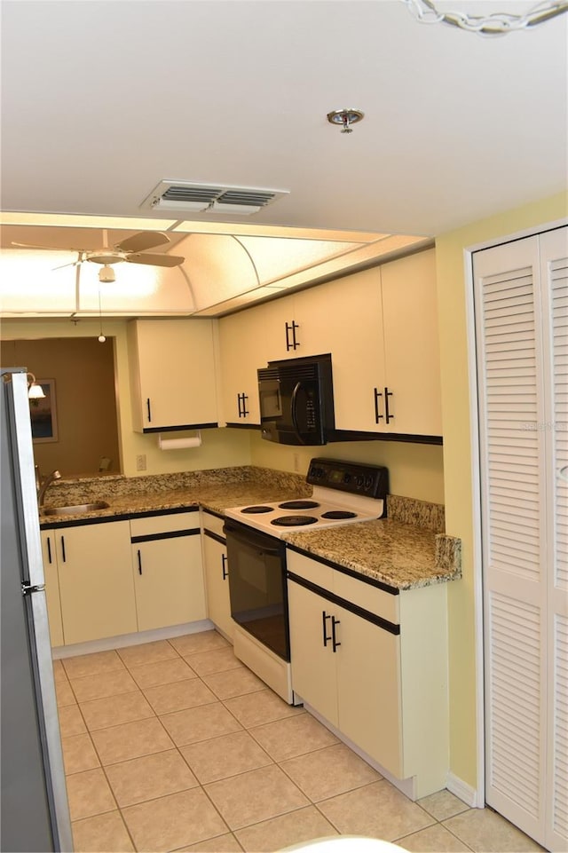 kitchen featuring white range with electric cooktop, sink, stainless steel refrigerator, and light tile patterned floors