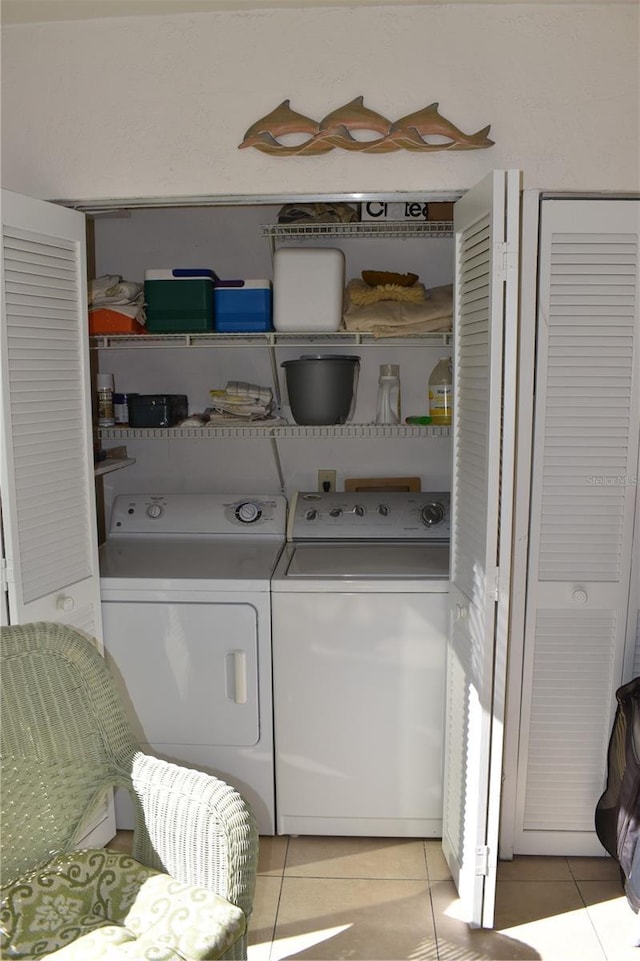 laundry room featuring washing machine and dryer and light tile patterned floors