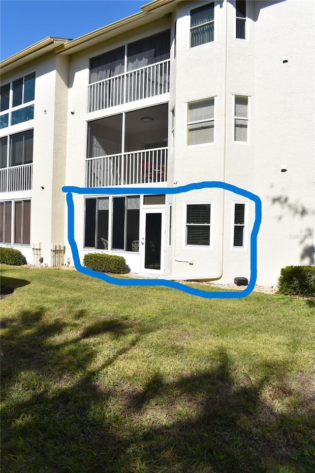 rear view of house featuring a lawn