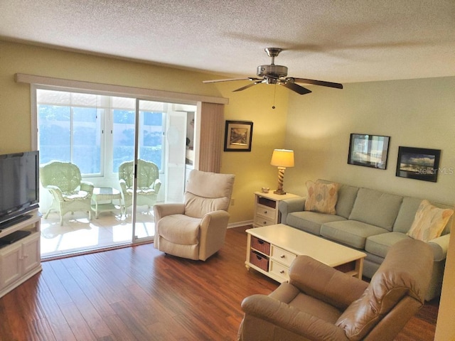 living room with ceiling fan, dark wood-type flooring, and a textured ceiling