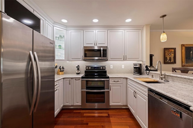 kitchen with white cabinets, decorative light fixtures, stainless steel appliances, and sink