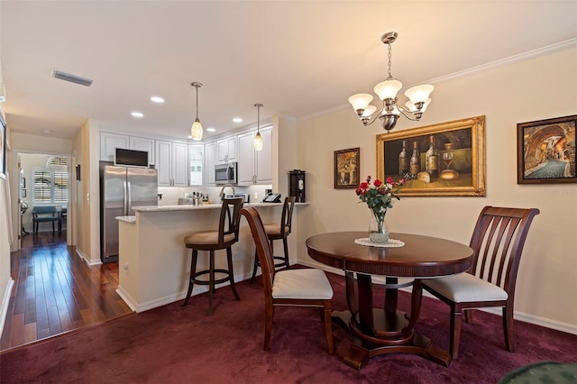 dining room with a notable chandelier, dark hardwood / wood-style floors, and ornamental molding