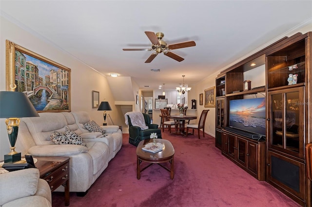 living room featuring carpet flooring, crown molding, and ceiling fan with notable chandelier