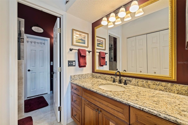 bathroom with tile patterned flooring, vanity, and a textured ceiling