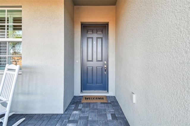 doorway to property featuring stucco siding