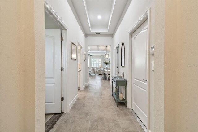 hallway featuring visible vents and baseboards