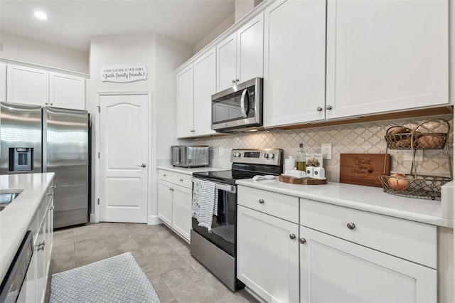 kitchen featuring light tile patterned floors, white cabinets, decorative backsplash, appliances with stainless steel finishes, and light countertops