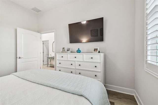 bedroom featuring visible vents, baseboards, and wood finished floors