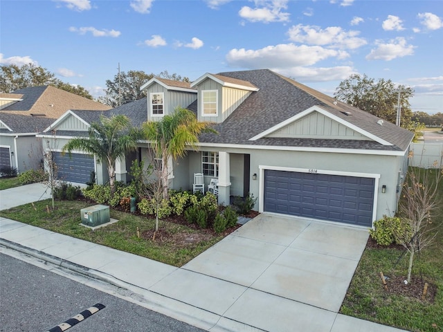 view of front of house with concrete driveway, roof with shingles, an attached garage, and stucco siding