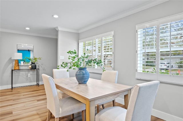 dining space featuring light hardwood / wood-style floors and crown molding