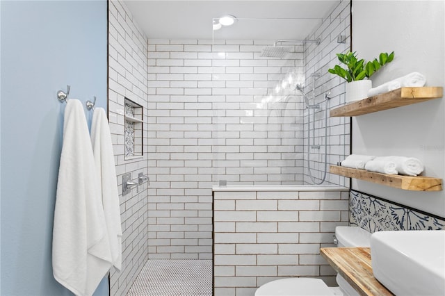 bathroom with toilet and a tile shower