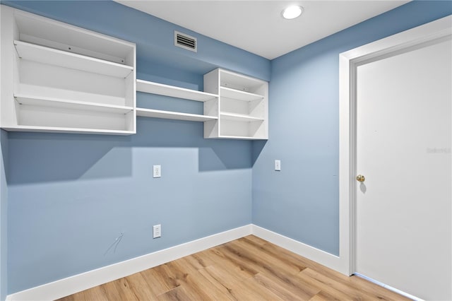 laundry area with wood-type flooring