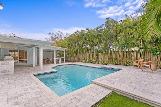 view of swimming pool featuring ceiling fan and a patio area