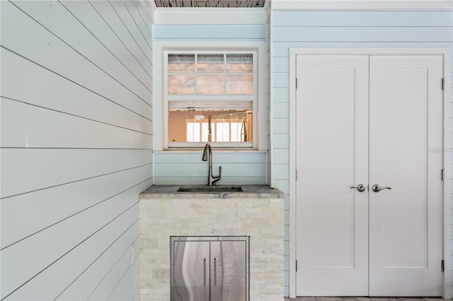 bathroom featuring sink and wooden walls