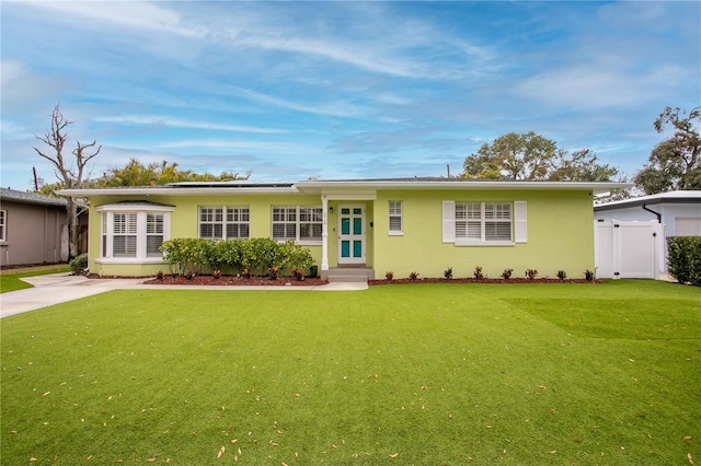 ranch-style home with a front lawn and solar panels