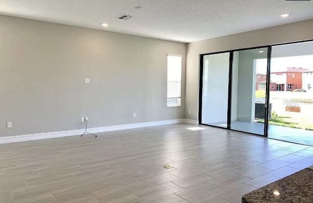 spare room featuring a textured ceiling and plenty of natural light