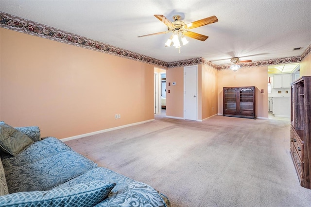 living room featuring a textured ceiling, light colored carpet, and ceiling fan