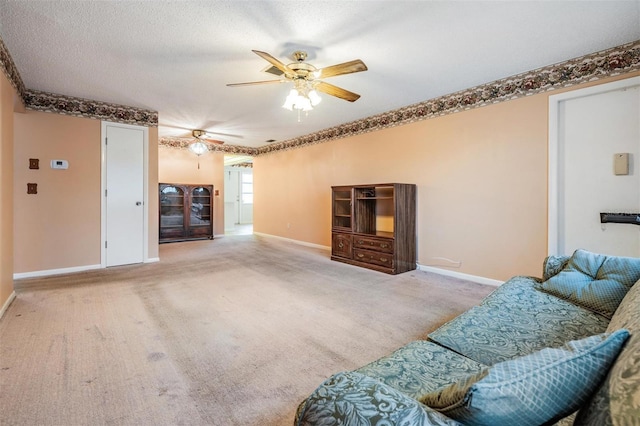 living room featuring light carpet, ceiling fan, and a textured ceiling