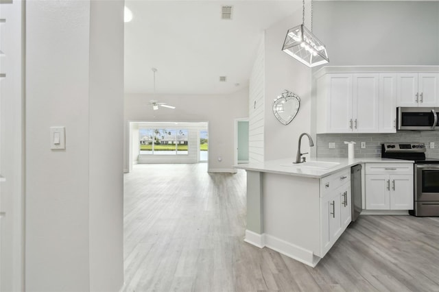 kitchen with backsplash, stainless steel appliances, ceiling fan, sink, and white cabinetry